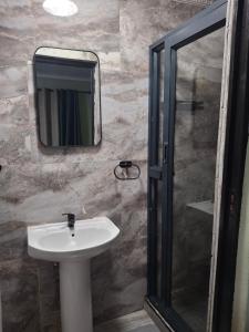 a bathroom with a sink and a mirror at Jacaranda Bnb in Khayelitsha +1 photo