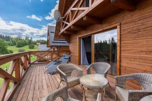 a deck with chairs and a table and a grill at Chata Michala in Dolný Kubín