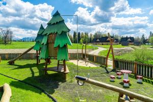 a playground with a tree on a slide at Jagodowa Osada - domki z balią z hydromasażem blisko term in Dzianisz