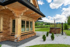 a log cabin with a large window on the side of it at Jagodowa Osada - domki z balią z hydromasażem blisko term in Dzianisz +96 photos