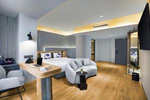 a hotel room with a bed and a desk at Fox Hotel Nagoya Batam in Nagoya