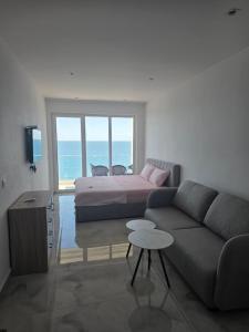 a living room with a bed and a couch at Amfora apartament Studio in Lezhë