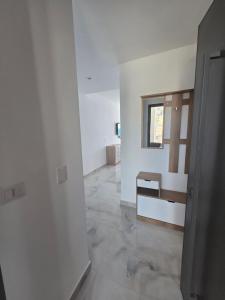 an empty room with white walls and a hallway at Amfora apartament Studio in Lezhë