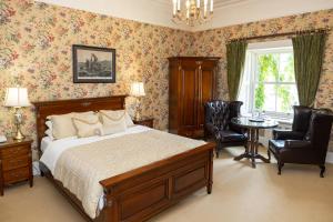 a bedroom with a bed and two chairs and a table at Gleeson's Roscommon in Roscommon