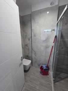 a bathroom with a toilet and a glass shower door at Amfora apartament Studio in Lezhë