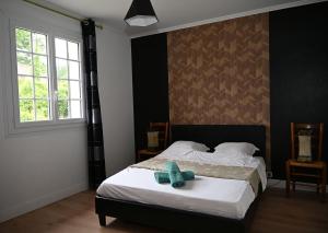 a bedroom with a bed with a blue teddy bear on it at Cottage des Moutons Espiègles in Saint-Martin-de-Nigelles