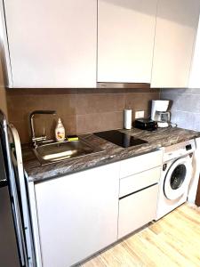 a kitchen with a sink and a washing machine at Limanaki 1 in Chios