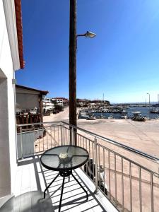 a table on a balcony with a view of a harbor at Limanaki 1 in Chios