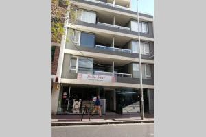 una persona caminando delante de un edificio en Departamentos Duarte Quiros en Córdoba