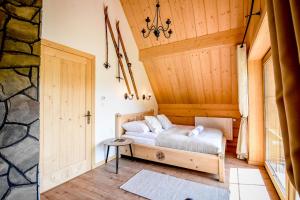 a bedroom with a bed in a wooden room at Jagodowa Osada - domki z balią z hydromasażem blisko term in Dzianisz
