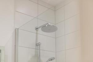 a shower with a glass door and a shower head at 1 Bed in Cromer oc-1844 in Cromer +16 photos