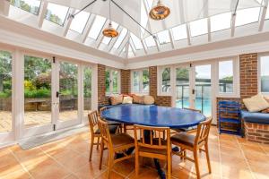 a dining room with a blue table and chairs at 5 Bed in Magham Down oc-sx942 in Hailsham
