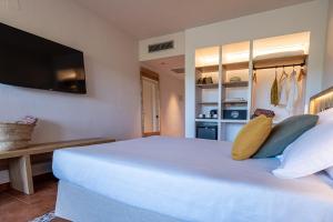a bedroom with a large white bed with a flat screen tv at Estival Park Marena in La Pineda