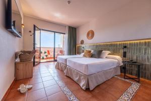 a bedroom with a large bed and a balcony at Estival Park Marena in La Pineda