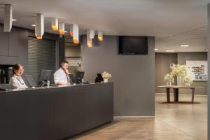 two people sitting at a counter in an office at Estival Centurión Playa in Cambrils