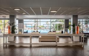a lobby with tables and chairs and a pool at Estival Centurión Playa in Cambrils