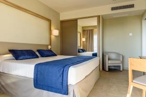 a bedroom with a large bed with blue pillows at Estival Park Almaris in La Pineda +41 photos