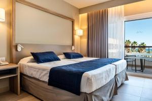 a bedroom with a large bed and a balcony at Estival Park Almaris in La Pineda