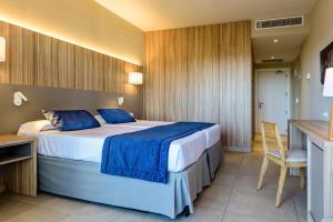 a bedroom with a large bed with blue sheets at Estival Park Almaris in La Pineda
