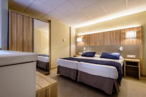 a hotel room with a large bed and a mirror at Estival Park Almaris in La Pineda