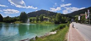 a person riding a bike on a road next to a lake at HausTipTop in Flachau