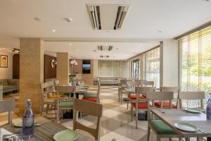 a dining room with tables and chairs and windows at Comfort Inn Elite in Jua
