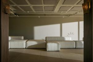 a room with three white couches in front of a window at Estival Maramar in Comarruga