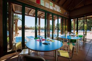 a restaurant with blue tables and chairs and windows at Camping Estival Torre de la Mora in Tamarit