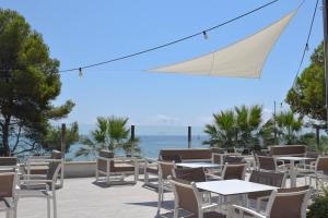 a patio with tables and chairs and the ocean at Camping Estival Torre de la Mora in Tamarit