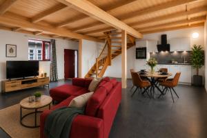 a living room with a red couch and a table at Elementa City Lodge Quedlinburg 4 in Quedlinburg