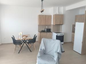 a kitchen with a table and chairs and a white refrigerator at Oikonomou Villas 2 in Ermioni