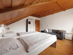 a bedroom with a large white bed and a couch at Vila Bělá pod Pradědem in Bělá pod Pradědem