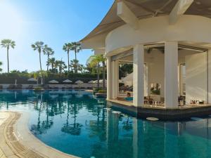 a pool at a resort with palm trees at Olympic Lagoon Resort Paphos in Paphos