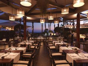 a restaurant with white tables and chairs and lights at Olympic Lagoon Resort Paphos in Paphos