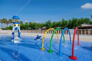 a water slide in a swimming pool with a lighthouse at Camping Estival Vendrell Platja in Comarruga