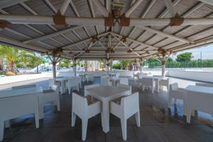 a dining area with white tables and white chairs at Camping Estival Vendrell Platja in Comarruga