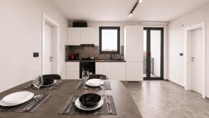 a white kitchen with a table with plates and glasses at Art Suite - Private Parking in Oradea