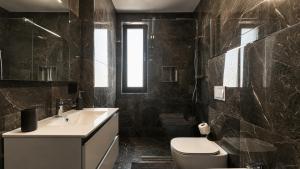 a black bathroom with a sink and a toilet at Art Suite - Private Parking in Oradea +8 photos