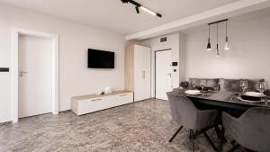 a living room with a dining room table with chairs at Art Suite - Private Parking in Oradea