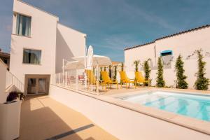 a balcony with a swimming pool and yellow chairs at Marea Boutique Hotel in Orosei