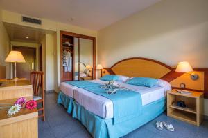 a hotel room with a large bed with blue sheets at Estival Park Silmar in La Pineda