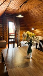 a vase of flowers sitting on a wooden table at AKVALIS комплекс для отдыха in Odesa