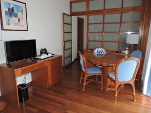 a room with a desk and a table with chairs at Estival Park Silmar in La Pineda +33 photos