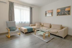 a living room with a couch and a table and a chair at Terminal Garden Apartman in Budapest