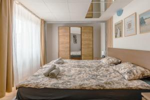 a bedroom with a bed with two stuffed animals on it at Terminal Garden Apartman in Budapest +15 photos