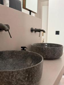 zwei Granitwaschbecken auf einer Arbeitsplatte mit zwei Wasserhähnen in der Unterkunft Merichas Luxurious Villa in Kythnos