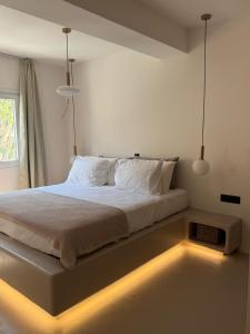 ein Schlafzimmer mit einem Bett und einer Lampe auf dem Boden in der Unterkunft Merichas Luxurious Villa in Kythnos