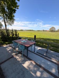 Ein Holztisch und Stühle vor dem Hintergrund eines Feldes in der Unterkunft Tiny House auf Pferdehof in Warendorf + 15 Fotos