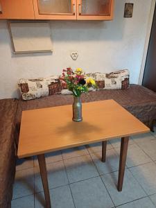 a vase of flowers on a table with a couch at Кацарила in Gabrovo