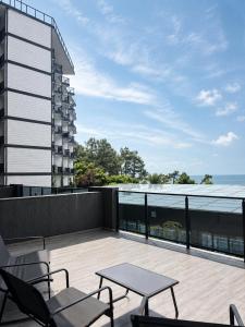 a balcony with a table and chairs and a building at Complex DEL MAR in Chakvi